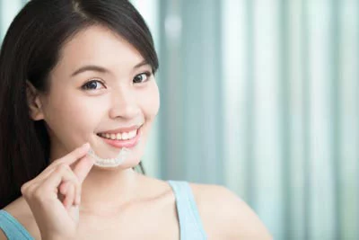 patient holding her new Invisalign clear braces