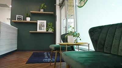 photo of a green couch inside the waiting room of Cook Street Village Dental